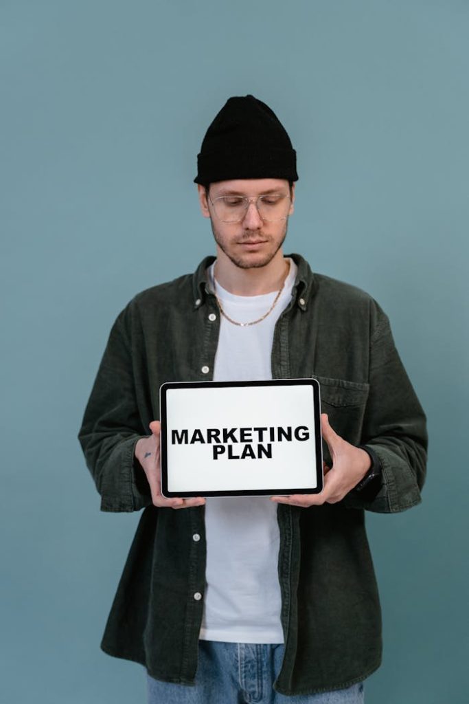 SEO-Tipps & EAT-Konzept: Das ultimative Domain Authority Webseitenverzeichnis Adult wearing casual clothing holding a tablet that reads 'Marketing Plan'.